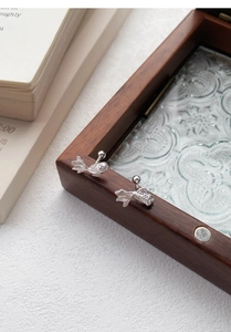 Macro detail of S999 silver koi fish earrings with screw back on vintage glass box