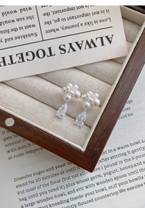 Detailed close-up of S999 silver pearl flower earrings with water drop zircon in jewelry box