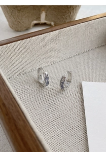Detail of S925 sterling silver hoop earrings with blue enamel and irregular texture
