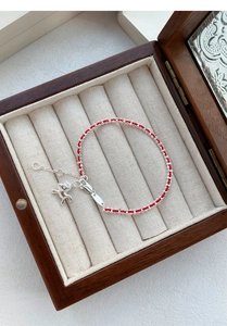 Détail d'un bracelet en fil rouge tressé avec breloque cheval en argent S925 en boîte