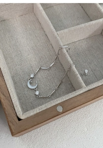 Detail of S999 sterling silver moon and star bracelet on a vintage wood jewelry box