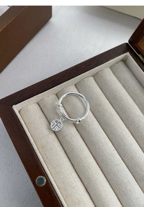 Detailed view of S925 silver ring featuring a round Fu pendant on a wooden jewelry box