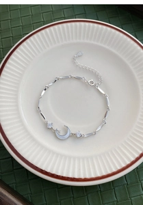 Macro shot of S925 silver moon bracelet with white shell inlay and sparkling zircons