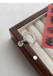 Macro detail of S925 silver adjustable ring with a Fu character pendant in a wood box
