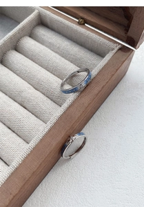 Détail de bagues de couple en argent S999 avec émail bleu étoilé et zircon en boîte bois