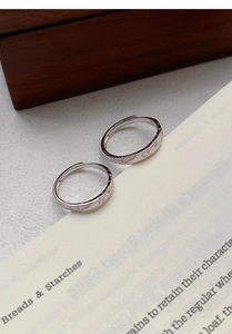 Detailed view of adjustable silver rings featuring engraved butterfly and floral motifs