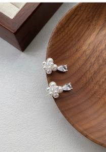 Macro shot of S999 silver flower earrings with pearls and teardrop zircon pendant