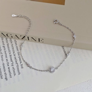 Elegant S999 sterling silver bracelet with sparkling zircon halo pendant on a book