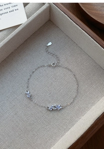 Close-up of S925 silver bracelet featuring blue floral pendants with cubic zirconia