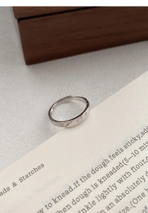 Macro shot of silver ring featuring delicate engraved firework patterns and open band details