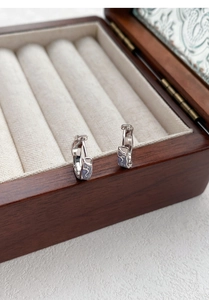 Detail of S925 silver hoop earrings with purple marble enamel on a jewelry box