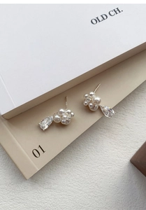 Detailed macro view of S999 silver flower earrings with pearls and a pear-cut zircon drop