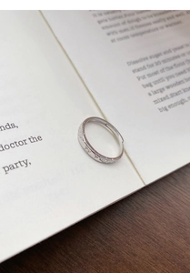 Close-up of S999 silver butterfly fireworks ring placed on an open book page