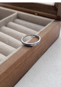 Détail d'une bague réglable en argent avec émail bleu, motifs d'étoiles et zircon