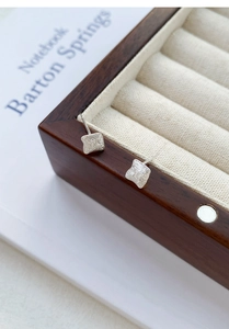 Detail view showing irregular brushed geometric square stud earrings in S999 silver