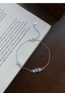 Macro detail of S925 sterling silver chain with blue enamel flowers and sparkling zircons