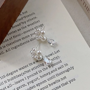 Elegant S999 silver flower earrings with pearls and teardrop zircon on a book