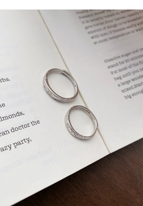 Macro view of S999 silver rings with intricate floral and butterfly carvings on a book