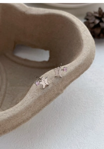 Makroaufnahme von S999 Silber Lebkuchenmann Ohrstecker mit einem rosa Zirkon-Detail