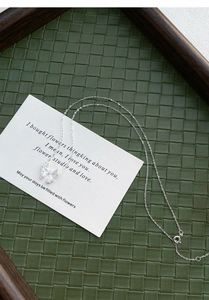 Detail of S999 silver butterfly pendant with textured finish on white prop card