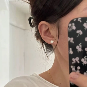 Minimalist S999 sterling silver geometric block earrings worn on ear with brushed texture