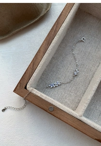 Detail showing the S925 sterling silver stamp and blue enamel flowers on the bracelet