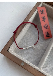 Close-up of S925 silver star pendant with Fu character on braided red string bracelet