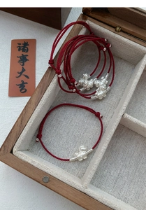 Macro shot of S999 sterling silver horse charm on red braided rope lucky bracelet with gift box