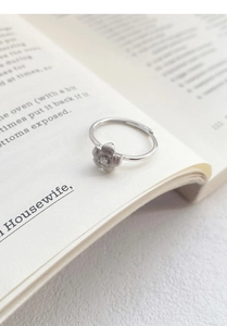 Detail of S999 silver hollow flower ring with brushed texture and zircon center