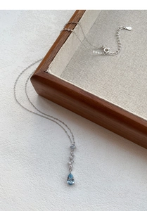Detailed close-up of blue teardrop zircon necklace with polished S999 silver chain