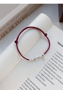 Close-up of S925 sterling silver star pendant on a red woven rope bracelet