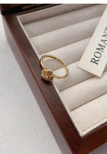 Detail view of a vintage S999 silver flower ring with brushed petals and a zircon center