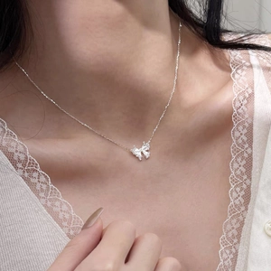 Elegant S999 sterling silver butterfly pendant necklace worn on a model's collarbone