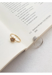 Detailed macro view of S999 silver flower rings with cubic zirconia and brushed texture