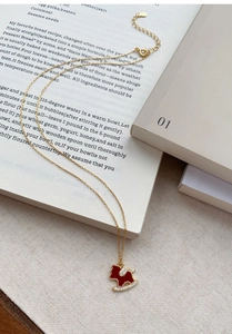 Détail du pendentif pégase en émail rouge sur chaîne dorée avec zircons étincelants