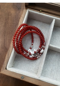 Dettaglio del bracciale in agata rossa con ciondolo gatto portafortuna in argento