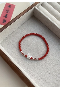 Dettaglio del bracciale in agata rossa con ciondolo a forma di coniglio in argento