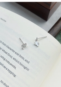 Détail de boucles d'oreilles chiot en argent S925 avec nacre blanche sur des pages