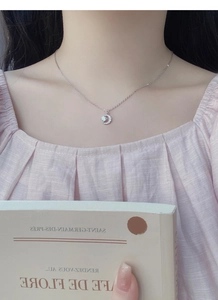 Primo piano della collana a mezzaluna con zirconi scintillanti su una modella