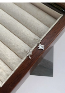 Détail de boucles d'oreilles licorne en argent S925 avec nacre blanche sur un écrin