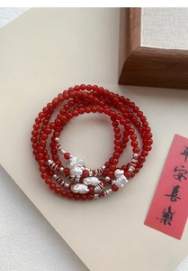 Vista dettagliata del bracciale con perline di agata rossa e ciondoli in argento S999 portafortuna