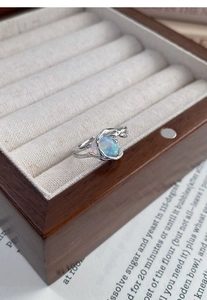 Detailed macro view of S925 silver lava ring with colorful opal on wooden jewelry box