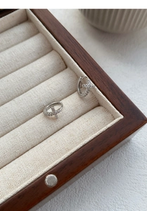 Detailed view of S999 silver cross earrings with pavé crystals in a jewelry box