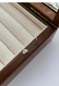 Detailed macro view of S999 silver rose and prince studs on a wooden jewelry box