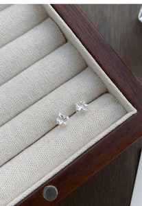Dettaglio dei piccoli orecchini a lobo orchidea in argento S999 con zircone lucido