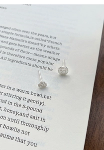 Macro shot of asymmetrical silver S999 stud earrings with rose and cartoon engraving
