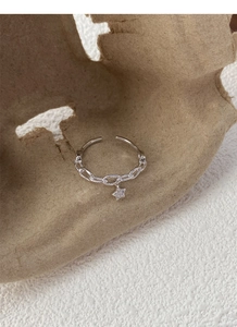 Détail d'une bague chaîne en argent S925 avec un petit pendentif en étoile brillante