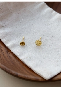 Detail view of gold-plated S999 silver rose and cartoon prince asymmetric stud earrings