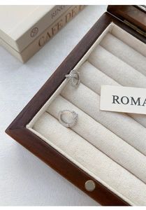 Close-up of S999 sterling silver cross hoop earrings with pavé zircons in a jewelry box