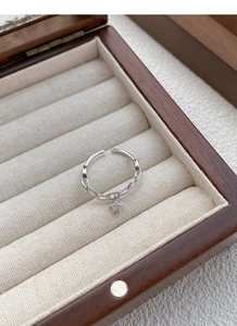 Gros plan d'une bague en argent avec breloque étoile dans un coffret à bijoux